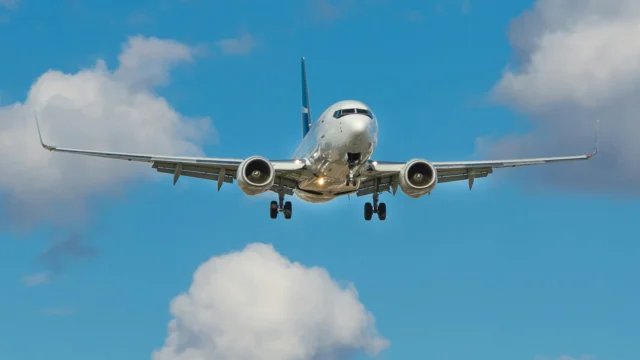 A passenger jet in flight above clouds