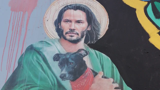 Keanu Reeves representado como "Jesucristo" con un perro negro símbolo de las protestas sociales en Santiago de Chile.
